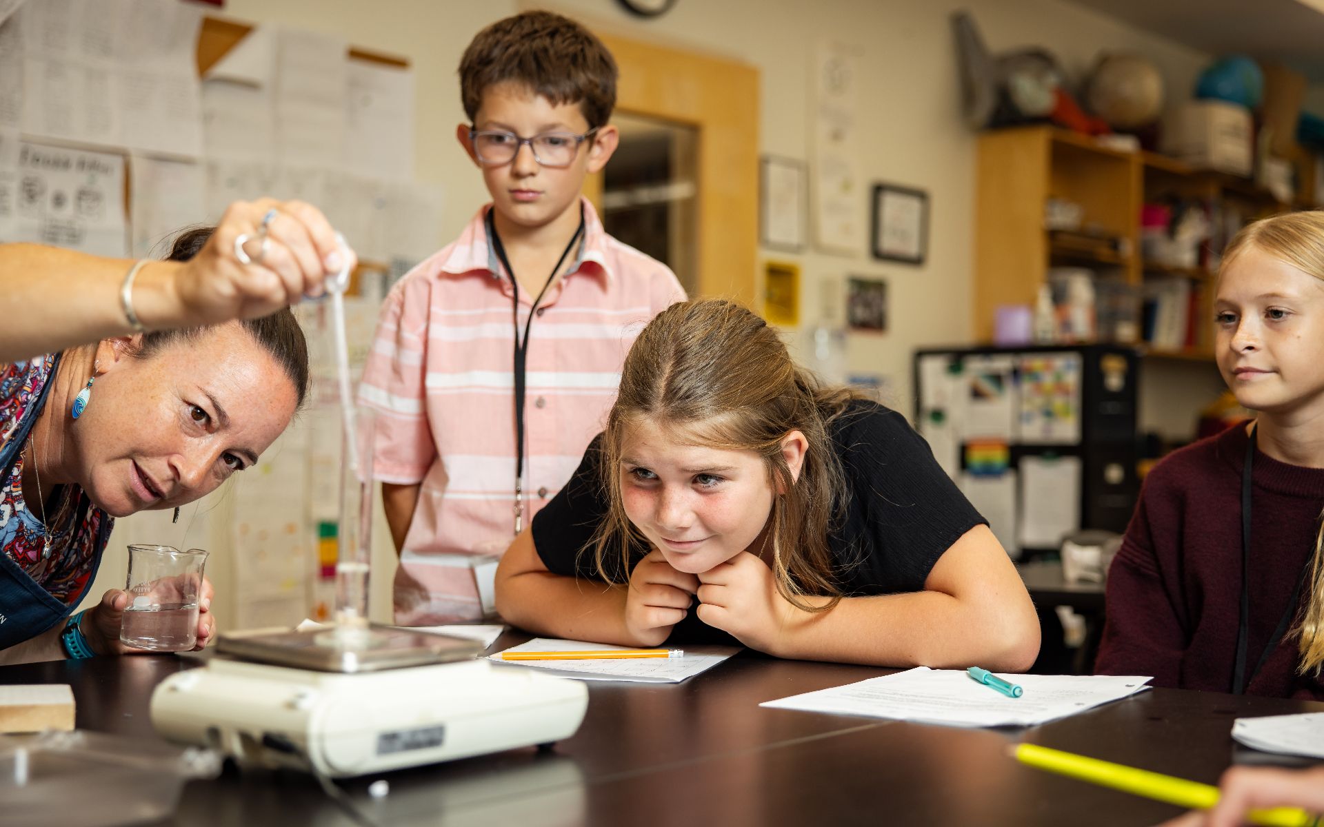 Teacher and students conduct a science experiment in a classroom