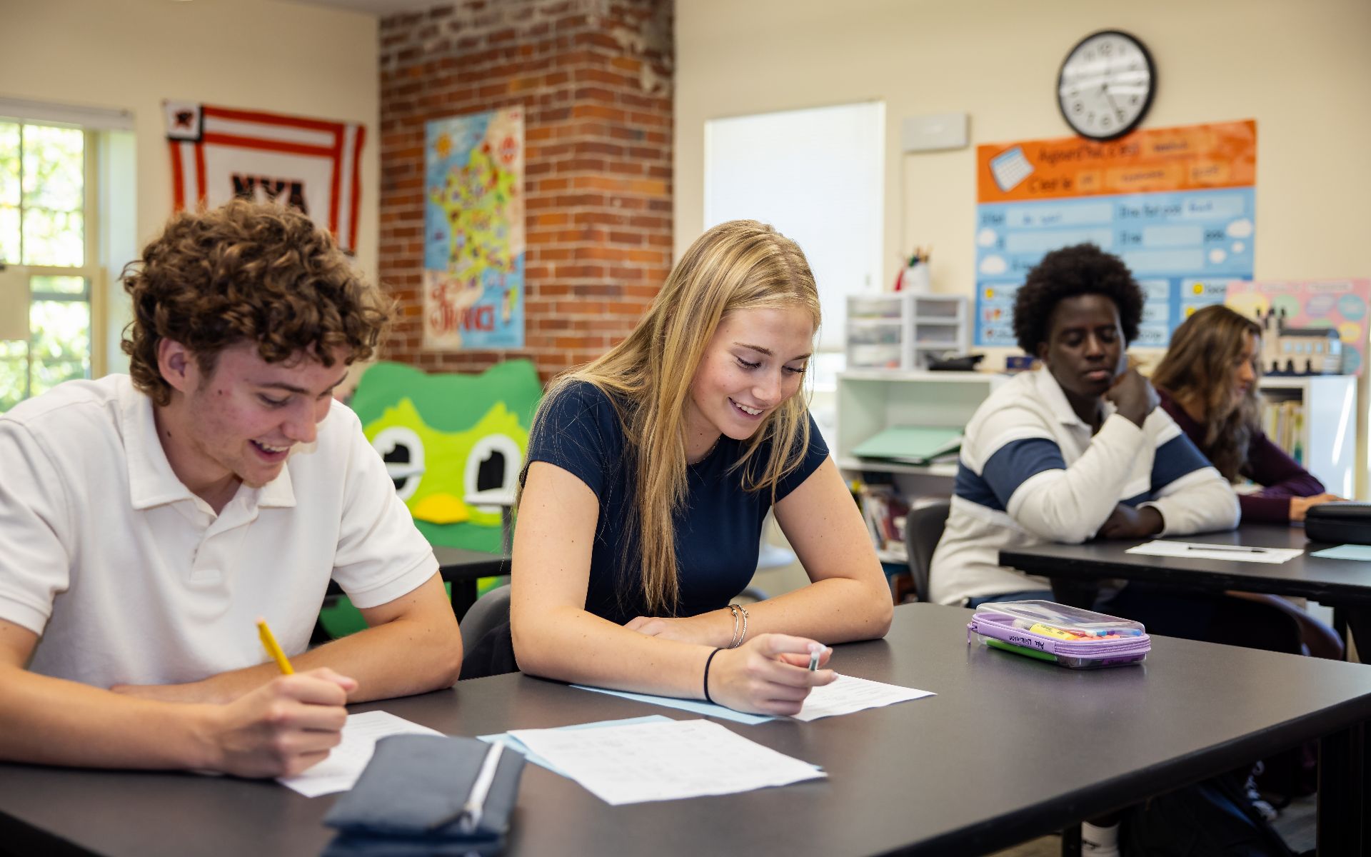 Diverse group of students engaged in schoolwork at their desks