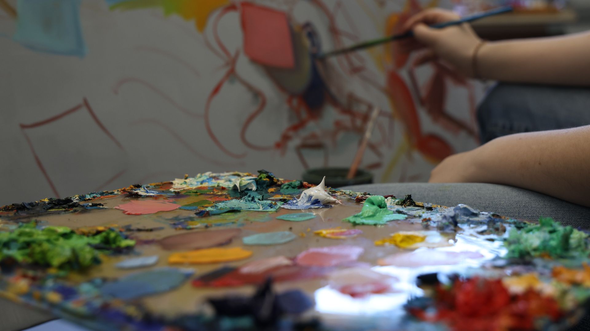An artist using a colorful paint palette