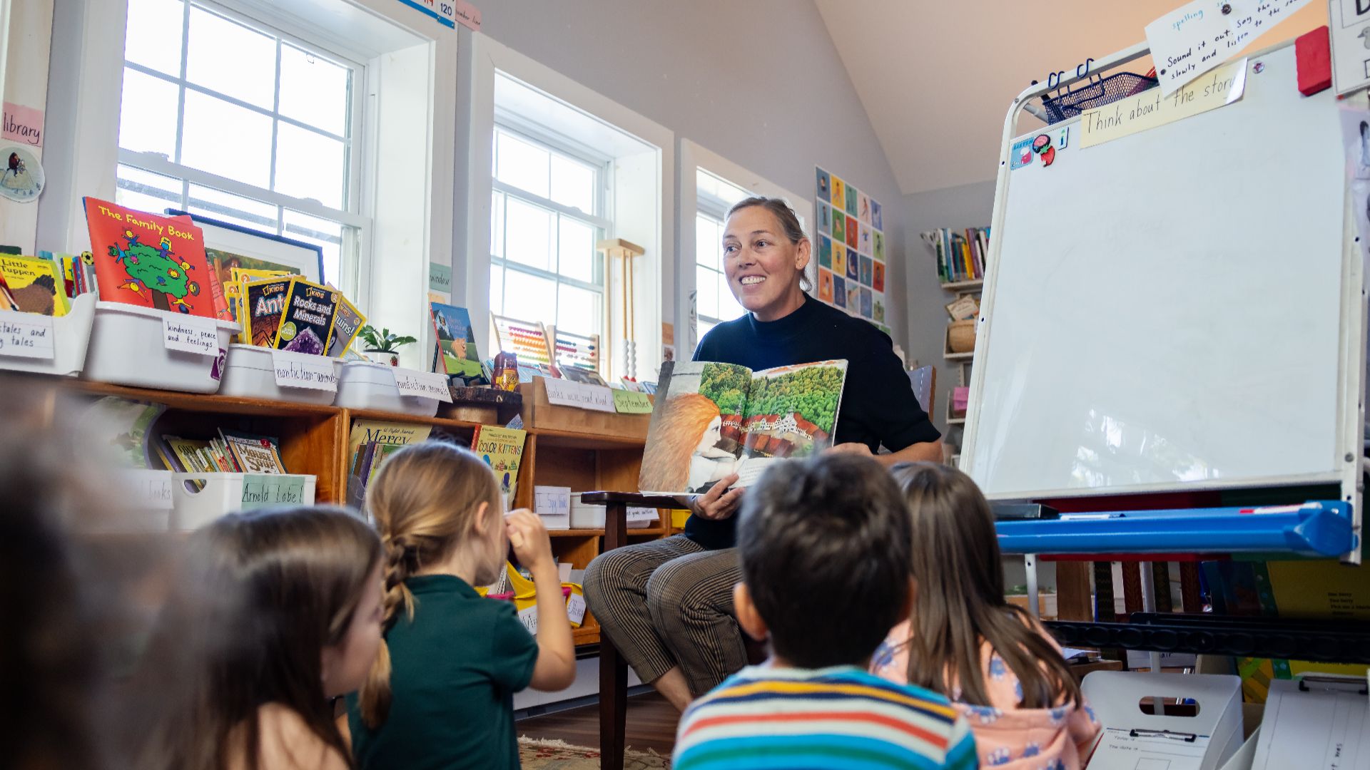 A teacher reading a storybook to a group of young students