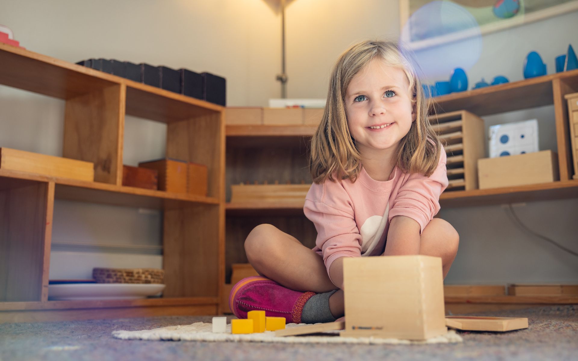 A young student playing with wooden blocks