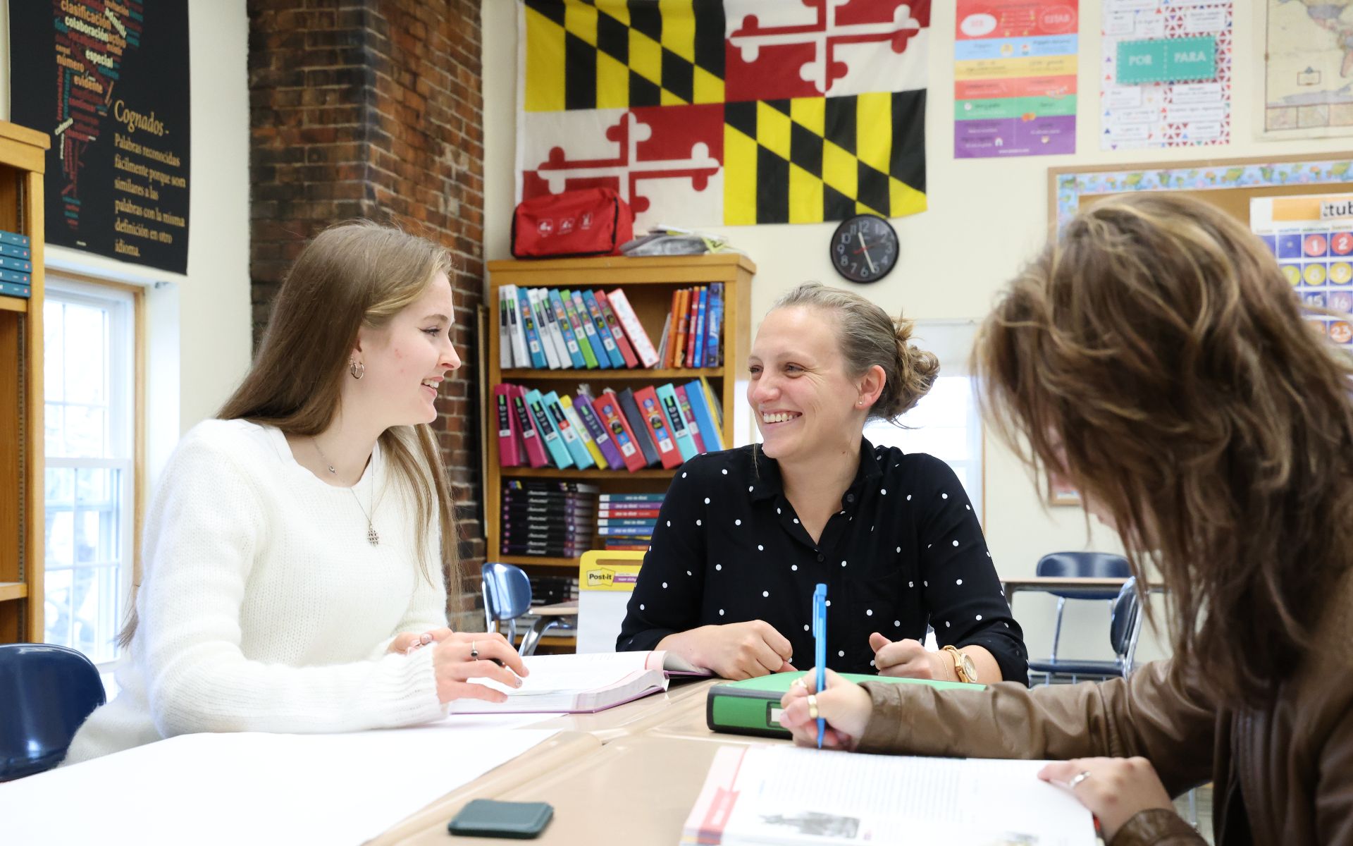 A teacher and students smiling during a discussion in a classroom